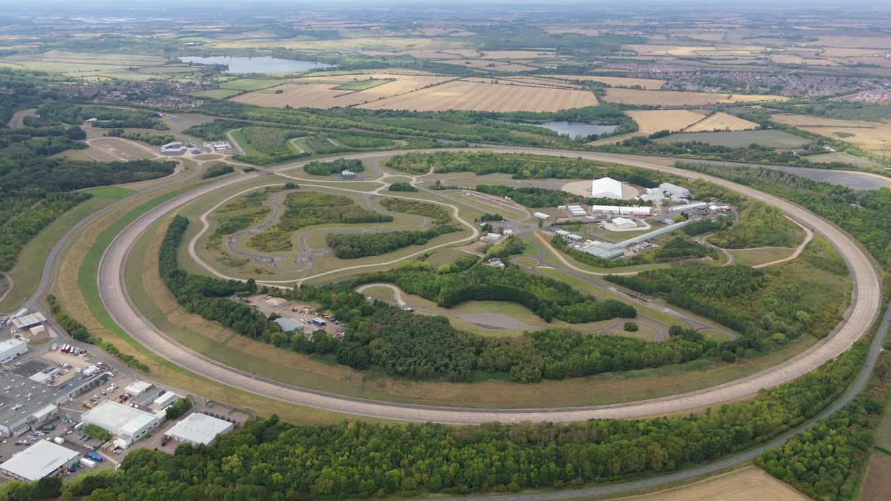 Aerial drone video of Bedford England proving grounds motor testing track with research on automotive innovation, cars and rural countryside hills