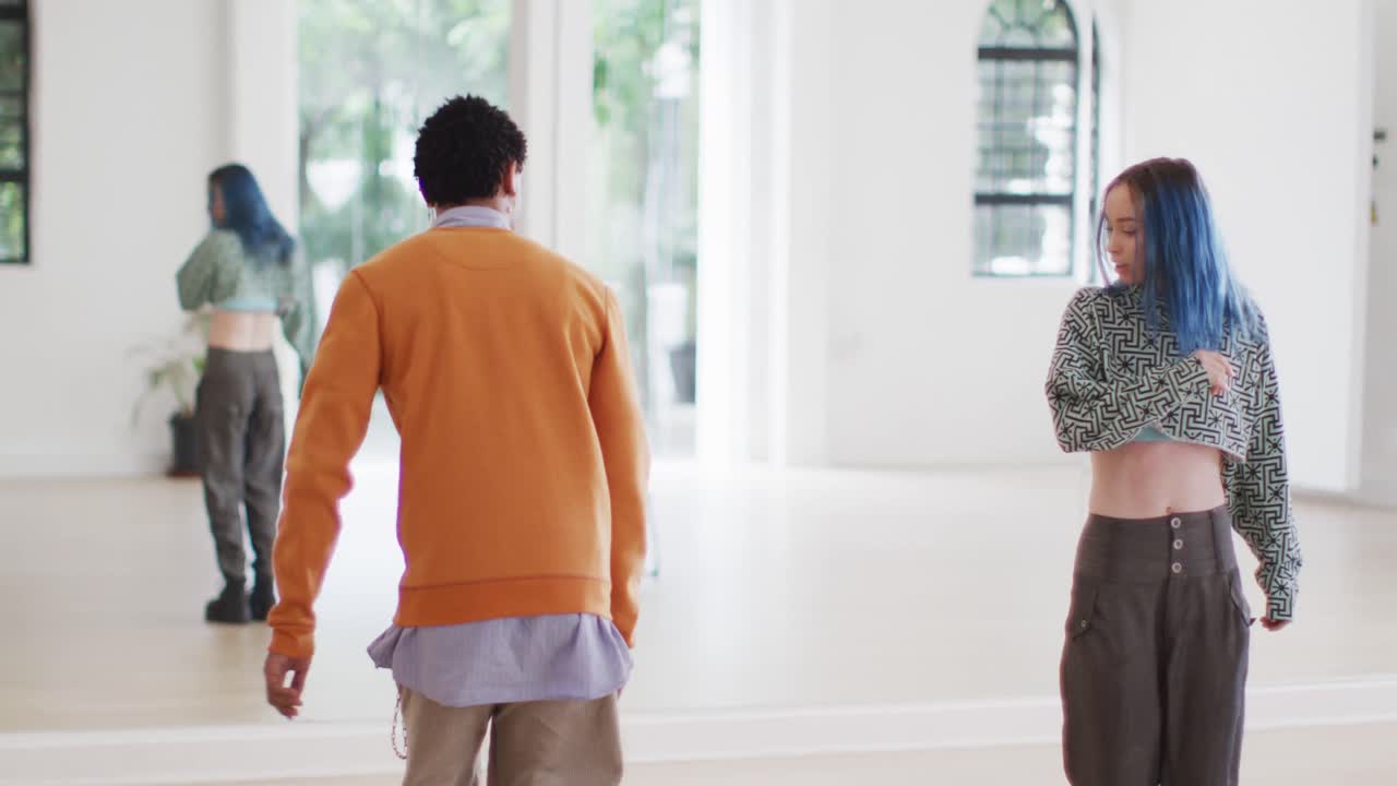 다양한 남녀 댄서들이 댄스 스튜디오에서 거울 앞에서 춤을 추고, 느린 움직임