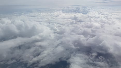 vista desde la ventana de un avión sobre nubes esponjosas en el cielo
