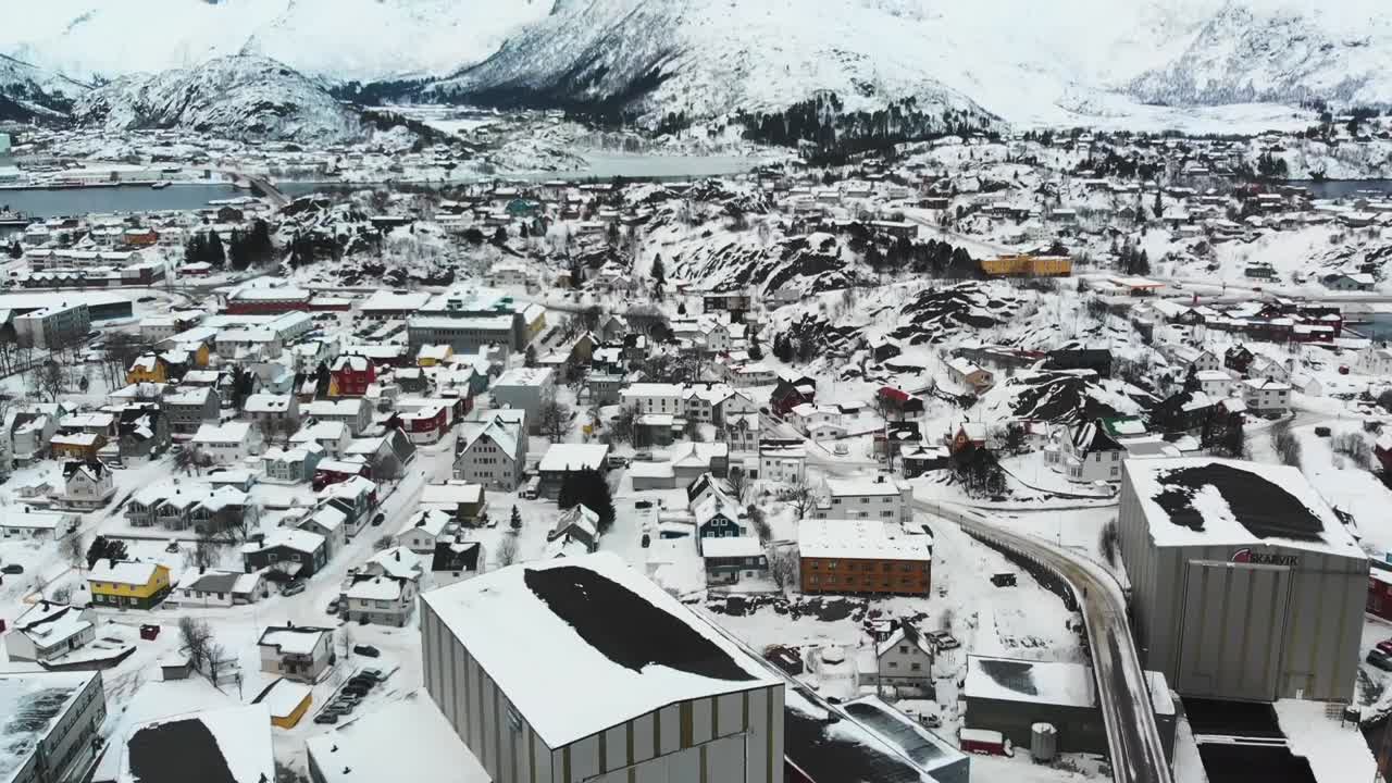 로포텐 섬의 배경에 산이 있는 겨울 동안 보트가 있는 항구의 노르웨이 도로