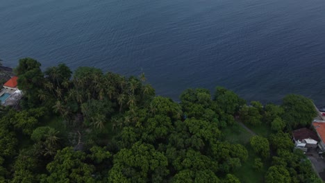 Drone-Inclinado-Hacia-Arriba-En-La-Costa-En-Un-Pueblo-Tropical-Frente-Al-Océano