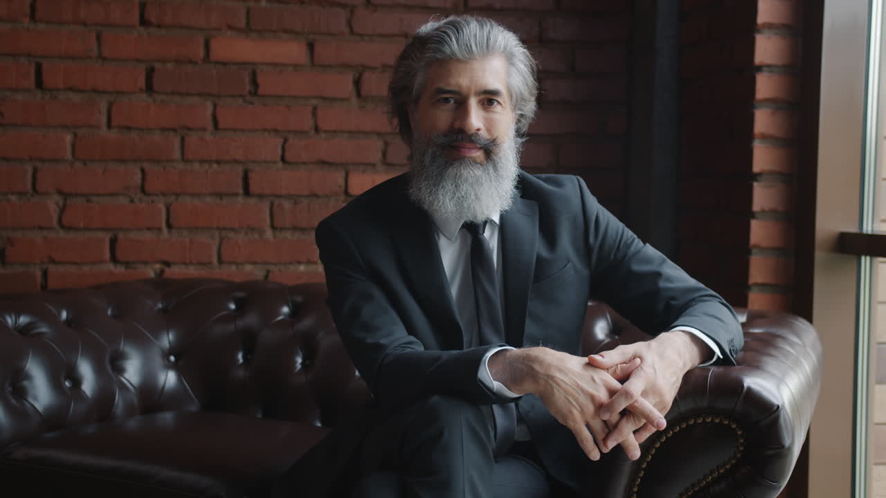 Businessman in a suit sitting on a leather sofa