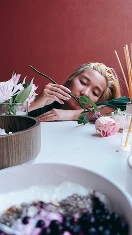 woman enjoying flowers and a healthy breakfast