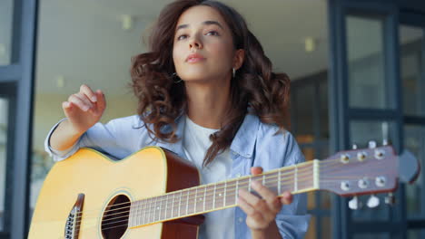 girl practicing music on guitar. thoughtful guitarist creating music on guitar