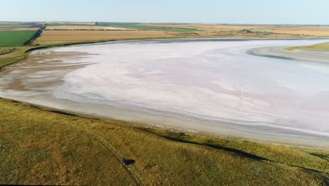 vista aérea de un lago salado rosado en un paisaje seco