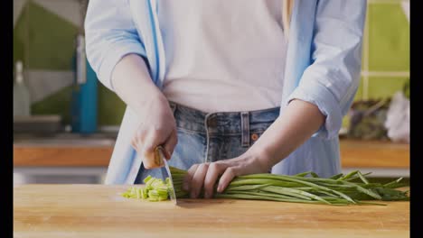 woman chopping green onions