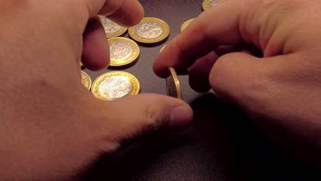 coin spinning by hand on a wooden table