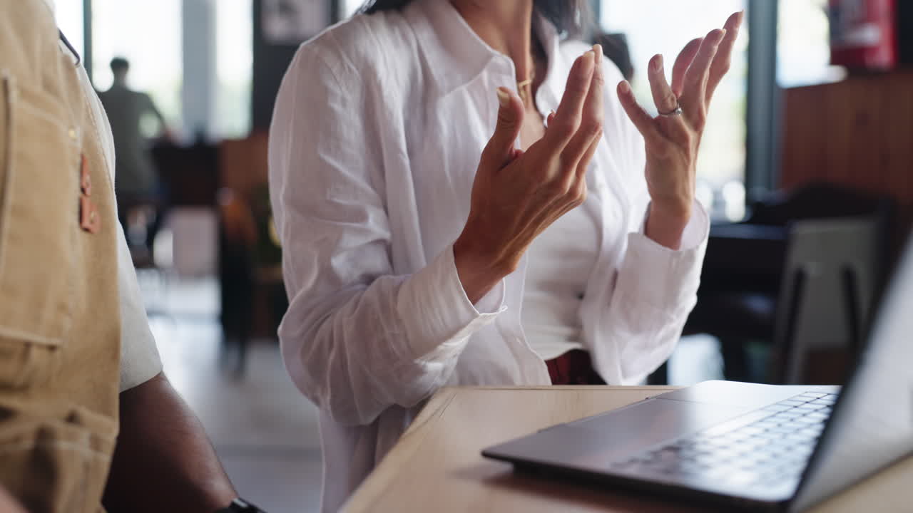 Woman Gesturing with Hands During a Business Discussion in a Cafe