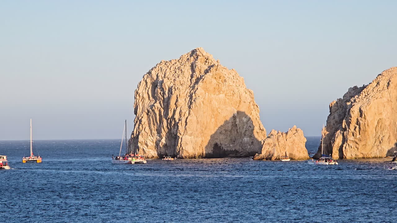 Iconic El Arco rock formation defining Land's End in Cabo San Lucas, Baja California Sur, Mexico, with boats navigating the surrounding deep blue ocean waters