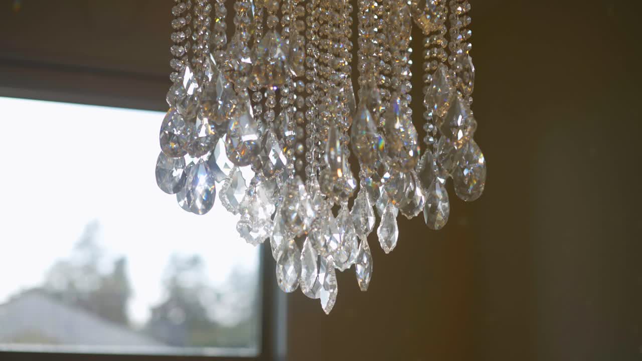 럭셔리한 가정집에서 햇빛이 쏟아지는 우아한 크리스털 샹들리에의 영화 같은 장면