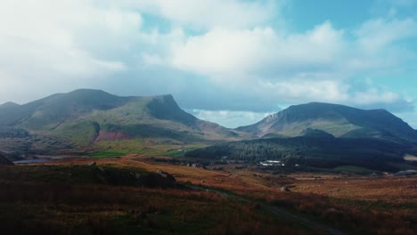 Aerial-slow-ascent-from-stone-wall-to-reveal-Snowdonia-in-the-distance