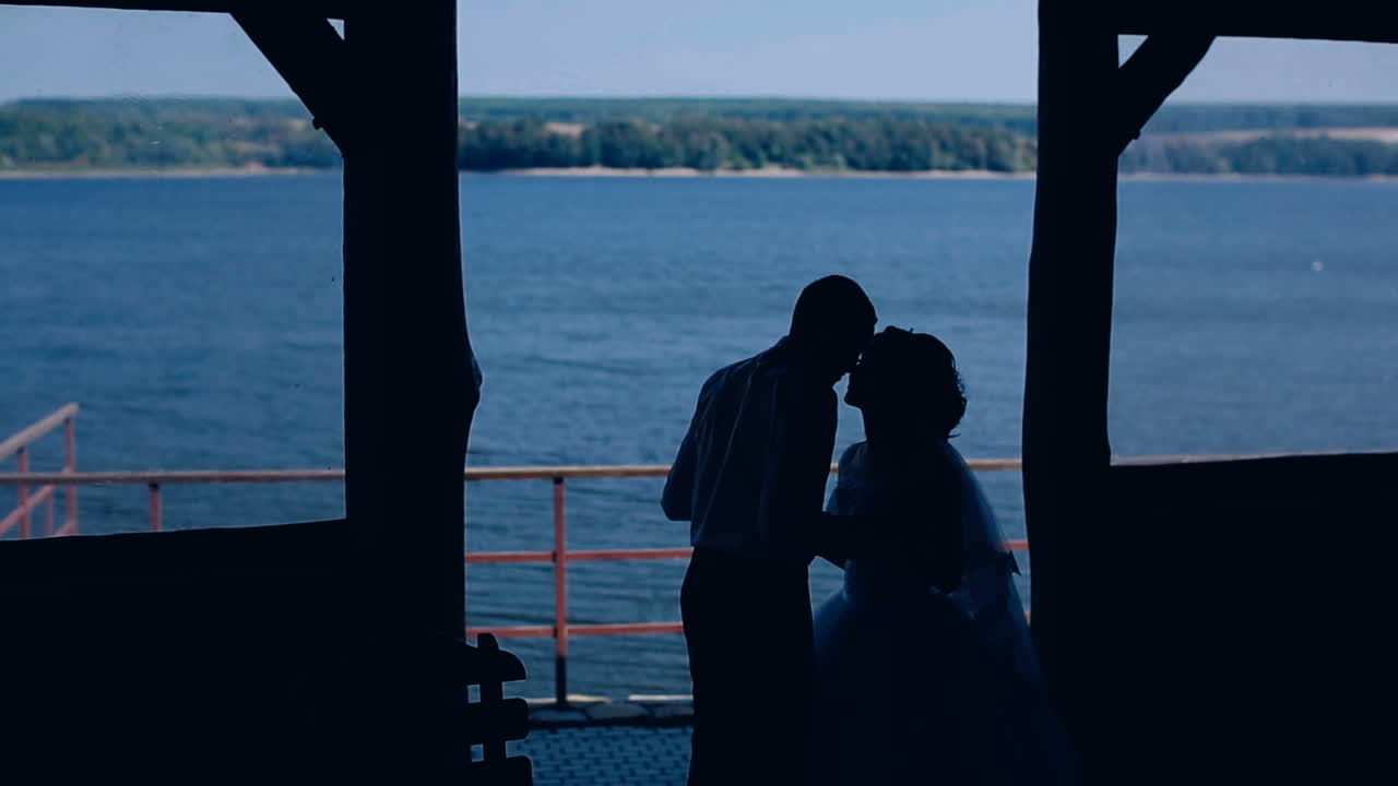 Wedding couple near lake. Bride and groom kissing near lake at sunset