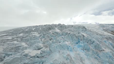 aerial flight over gigantic iced glacier landscape in buarbreen, norway during cloudy day