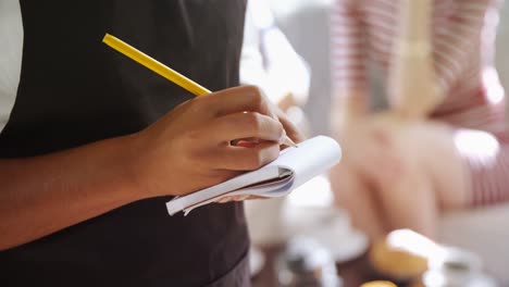 waitress writing on notepad in restaurant