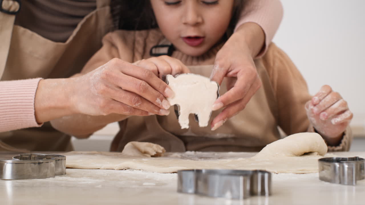 어머니와 딸이 쿠키를 고 있습니다.