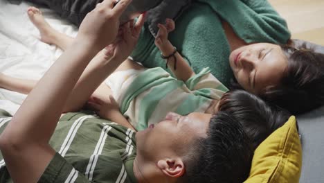 Happy-Young-Asian-Family-Using-Digital-Tablet-Computer-While-Enjoying-Quality-Time-Together-At-Home