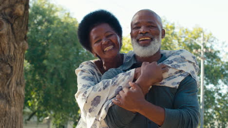 Portrait-Of-Loving-Senior-Couple-Standing-And-Hugging-Outdoors-In-Garden-Park-Or-Countryside