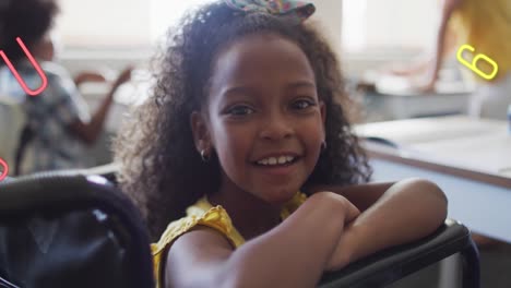 Animation-of-letters-and-numbers-over-happy-biracial-schoolgirl-in-wheelchair-at-desk-in-class