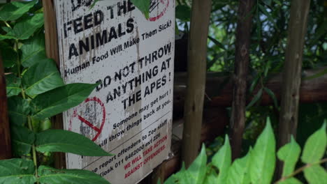 do not feed the animals signage at zoo, slow full high angled panning shot left to right