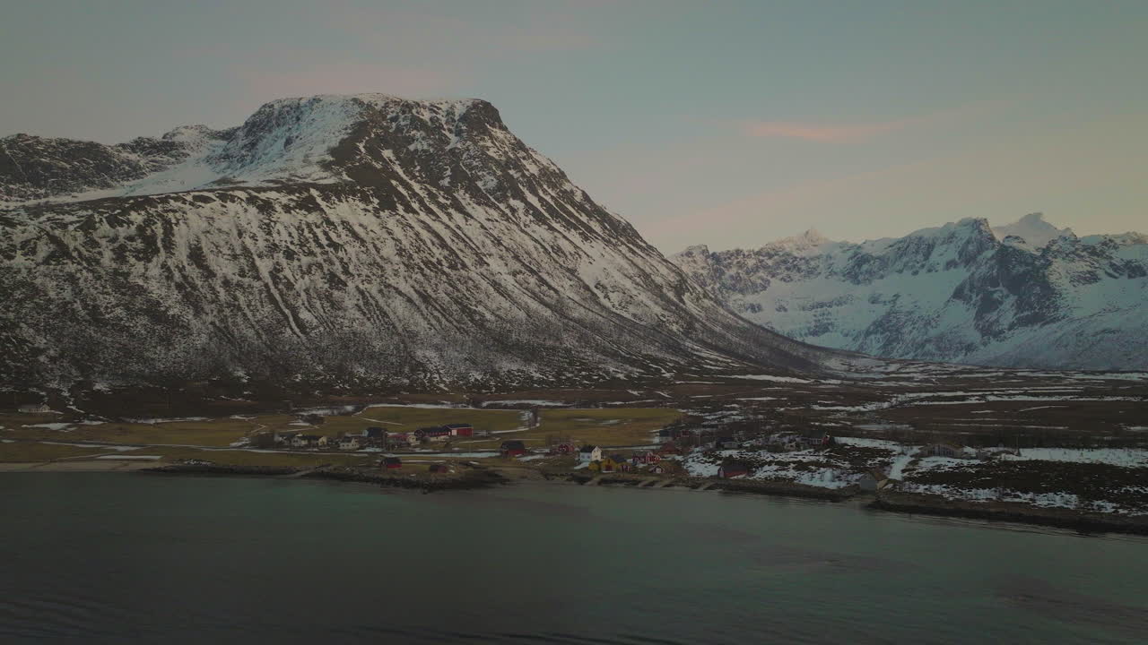 Friedliches Dorf Tromvik in Norwegen, schneebedecktes Fjordtal, Luftaufnahme