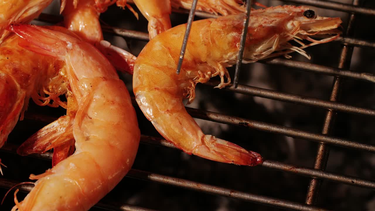 Chef cooking shrimps with oil and spices on grill close-up. Prawns on fire throwing them on pan. Restaurant Food concept. Sea food barbecue.