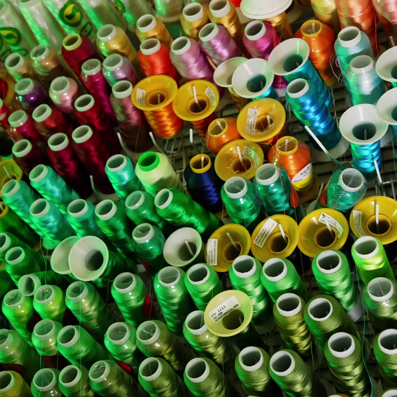 Background of colorful spools.Rows spools of thread of different colors for the sewing machine. Bright colors of threads on the table