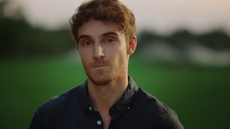 Uomo pensieroso che si sente timido all'aperto. Ragazzo pensieroso in posa su un prato.