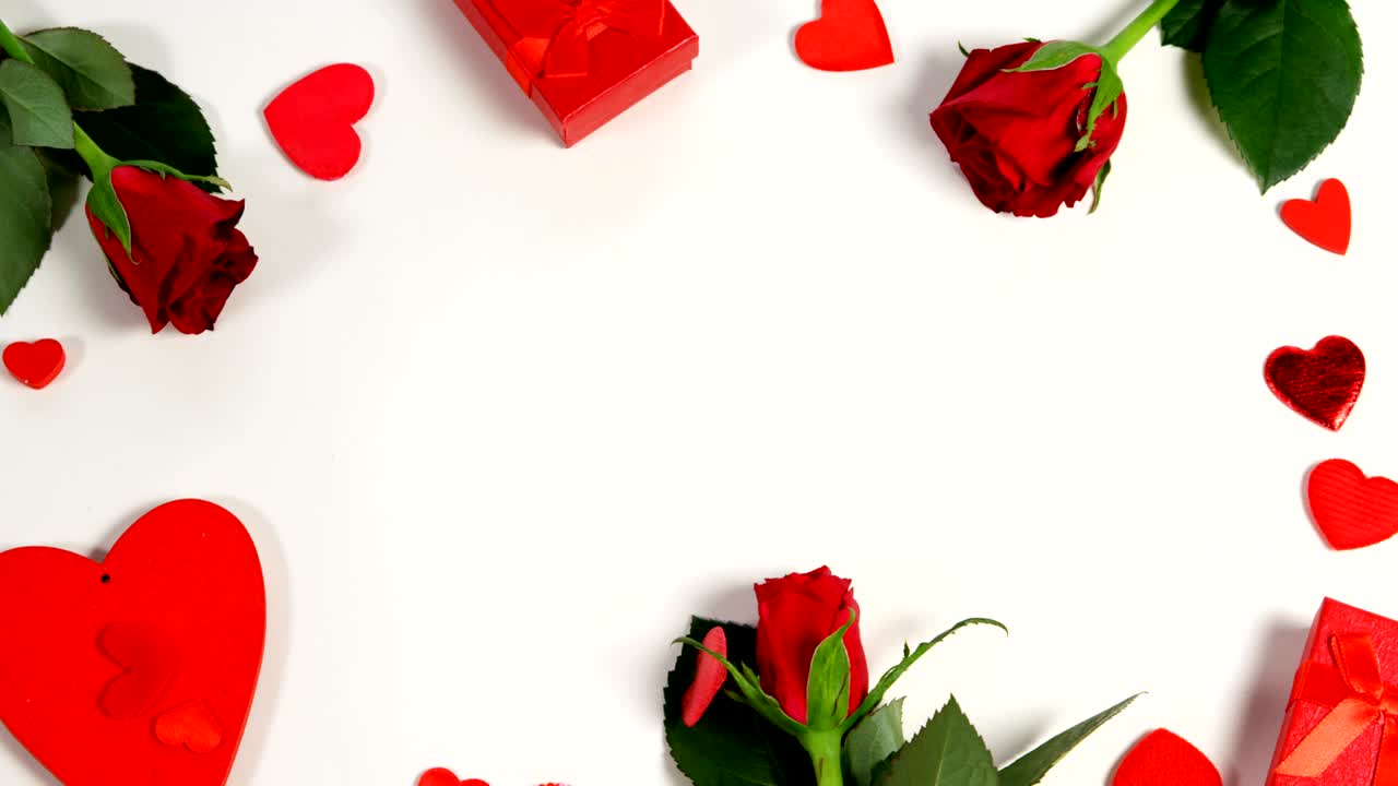 красные розы, подарочные коробки и конфеты в форме сердца на белой поверхности в форме круга 4k