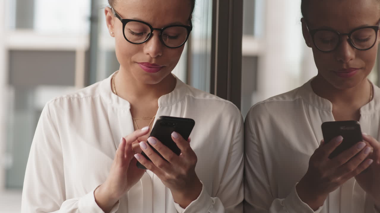 Woman using cell phone in office