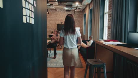 woman at workplace concept. camera follows young executive manager, female boss entering busy office slow motion.
