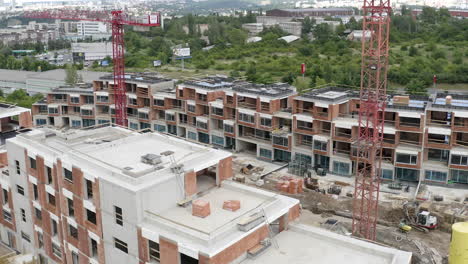 toma aérea de la construcción de nuevos apartamentos en una excavación de la ciudad, grúas