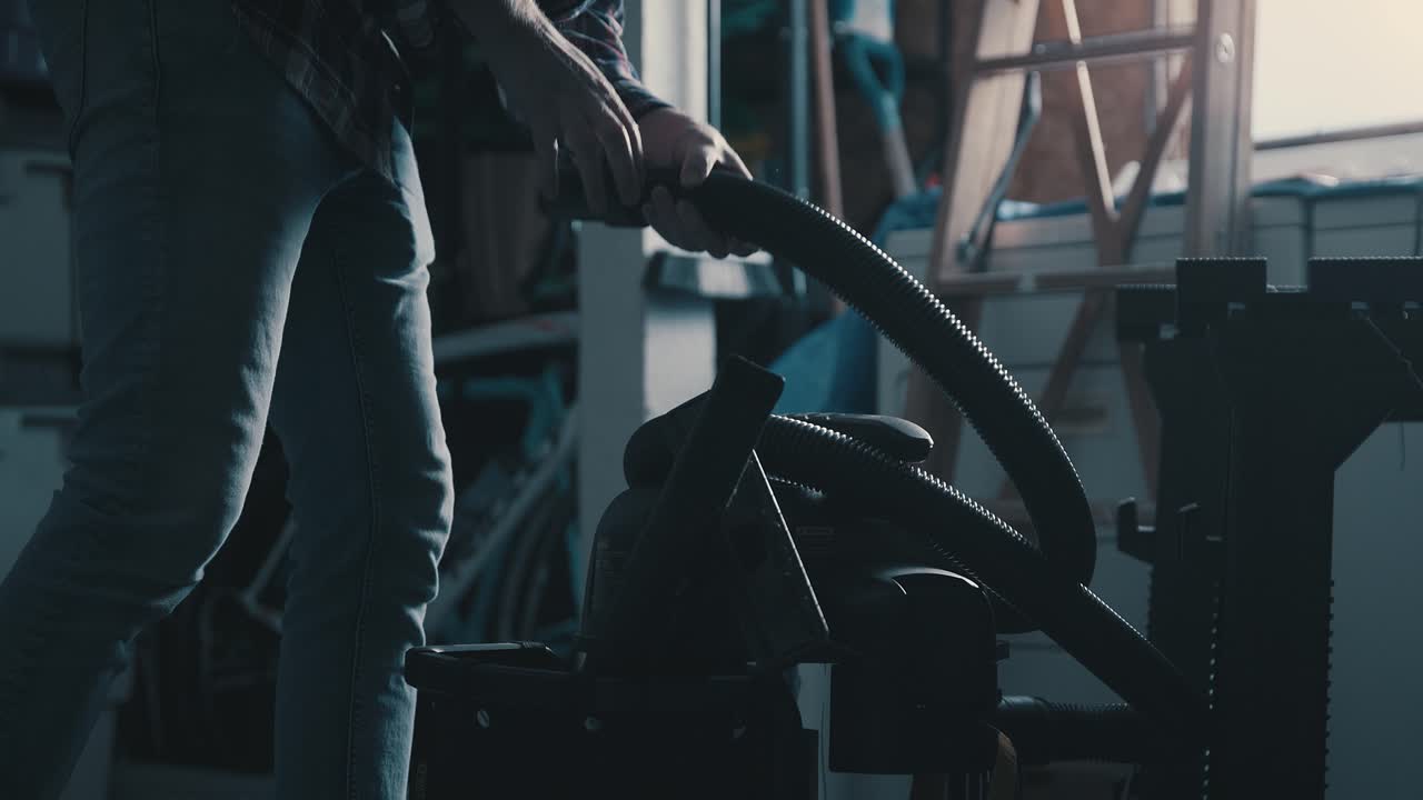 청소를 위해 가게 진공청소기를 풀고 준비하는 남자