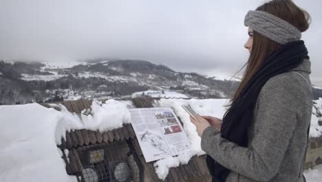 niña comunicándose a través de teléfono móvil mientras la fría brisa invernal le sopla el pelo, slomo