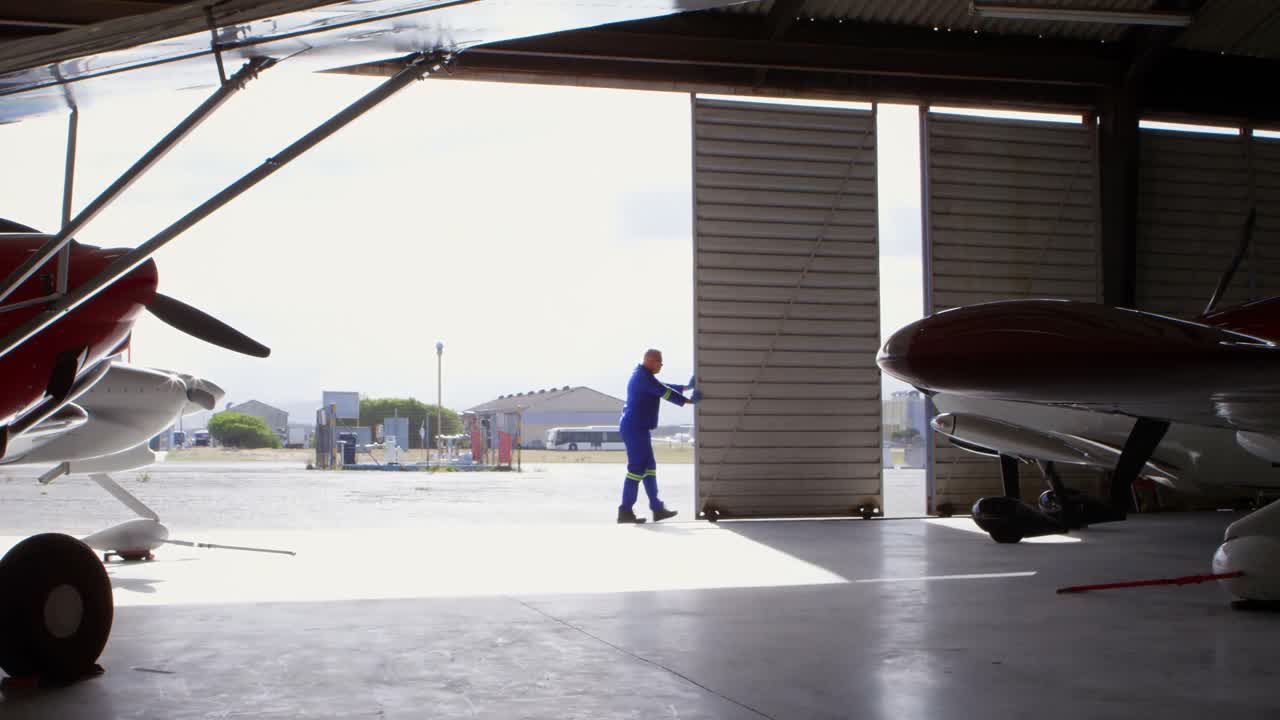 Ingegnere che chiude il portone dell'hangar 4k