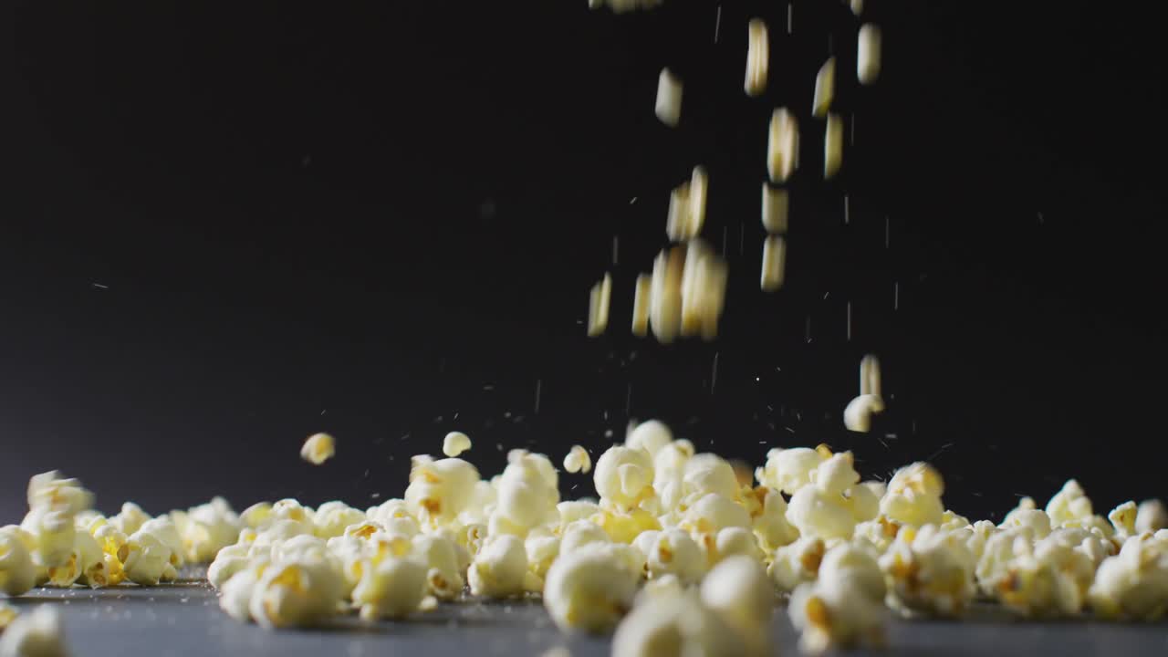검은 바탕에 떨어지는 팝콘의 클로즈업 비디오