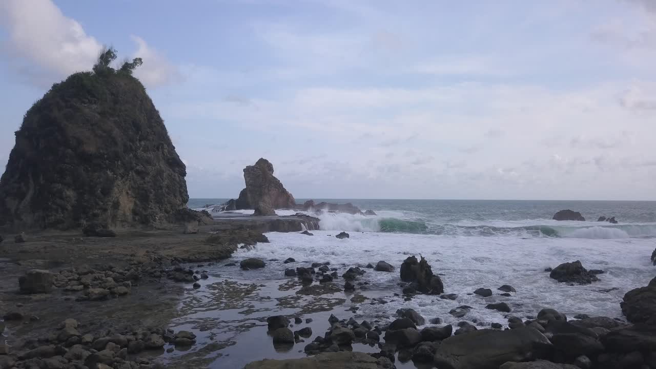 Watu Lumbung Beach in Gunungkidul, Yogyakarta. A beach with unique large rocks and corals. The waves crash against each coral.