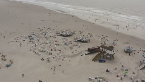 drone - aerial shot of the sandy beach with tourists and people in st