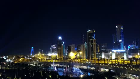 kuwait city at night with a musical water fountain. middle-east skyline. cinematic semi orbital shot