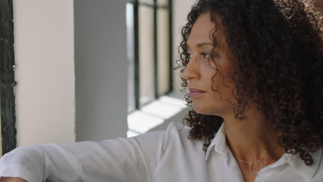 mature-mixed-race-woman-using-smartphone-drinking-coffee-at-home-enjoying-relaxed-morning-browsing-messages-looking-out-window-thinking-contemplative