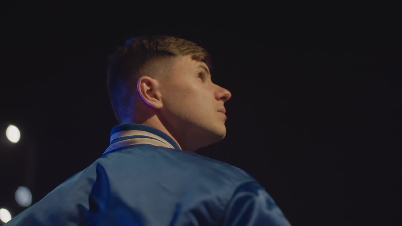 Youth observing city lights glow, Teenager watches shimmering bridge under city lights, Adolescent looks thoughtfully at shimmering streetlights and glowing bridge during nighttime cityscape