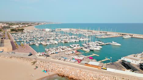 Aerial-4K-drone-footage-of-marina-next-to-El-Roc-de-Sant-Gaietà,-a-scenic-location