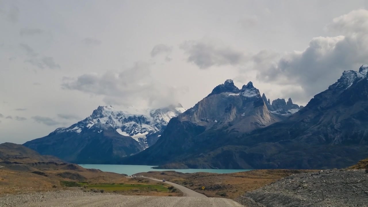 Conduite à travers la vaste nature sauvage du parc national Torres del Paine, Chili, vers les emblématiques Cuernos del Paine sous un ciel nuageux spectaculaire. Un road trip patagonien à couper le souffle à travers la nature.