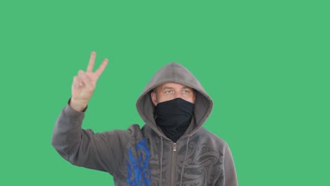 protester showing victory sign during riot or protest on green screen background