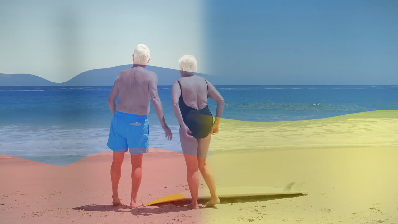 Walking on sunny beach, elderly couple with colorful animation in swimwear