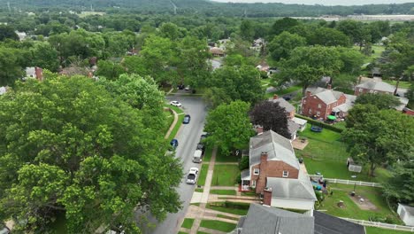 Red brick houses and chimney with pool in garden. quiet historic suburb neighborhood of American town. Aerial top down flyover shot. Sunny day in summer with green trees