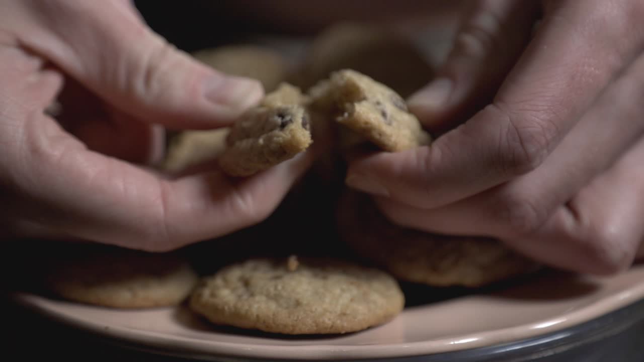 Fingers Breaking A Soft Nutty Whole Wheat Chocolate Chip Cookie - Closeup Shot