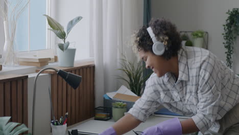 woman cleaning and dancing to music at home