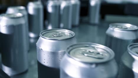 las manos del trabajador de la cervecería de producción recogiendo latas en una línea de envasado de cinta transportadora preparándose para el proceso de etiquetado. de cerca. imágenes de alta calidad en 4k