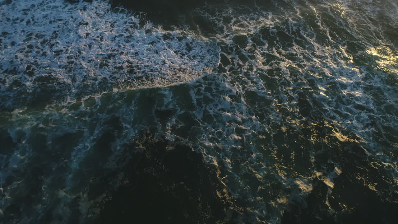 Aerial top down view of ocean waves during a beautiful sunrise at Miami Beach Gold Coast Australia