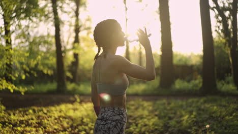 woman drinking water after exercise in the park